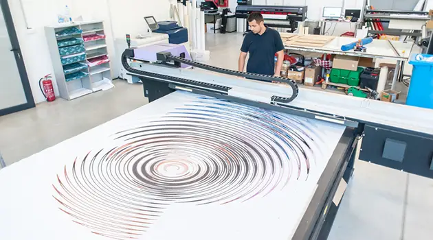 man operating large format printer