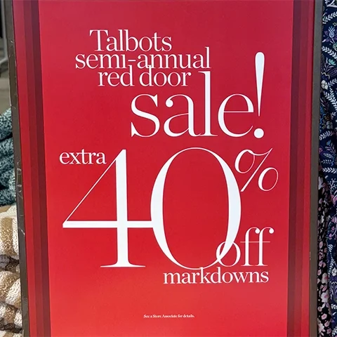 large format printed red for sale sign in store window
